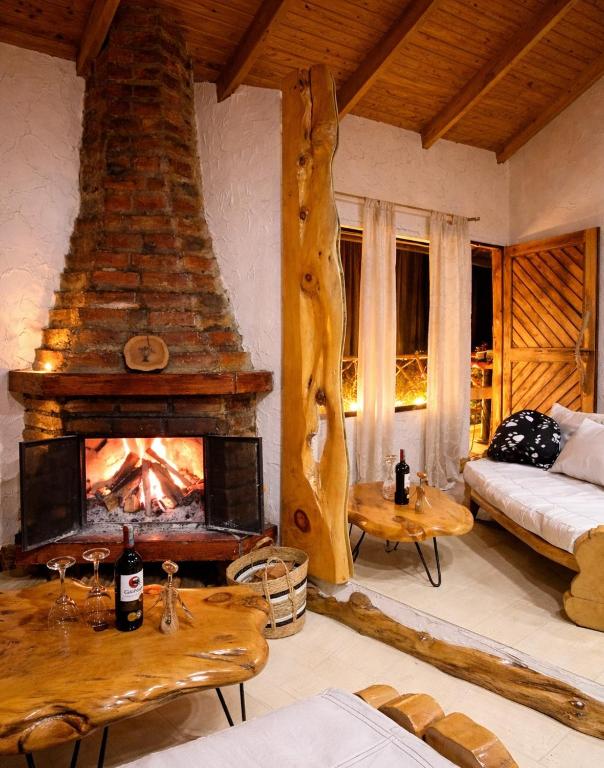 a living room with a fireplace and a bed at Cabaña en la Calera el Pinar in La Calera