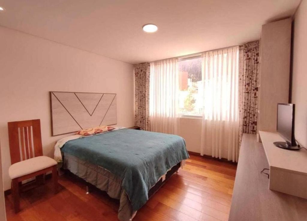 a bedroom with a bed and a desk and a television at Salma in cuzco apart in Cusco