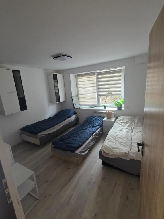 a room with three beds and a window at Noclegi Pracownicze Niepołomice in Niepołomice