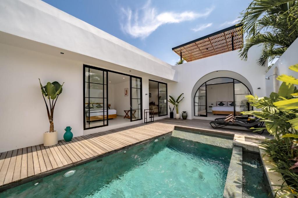 a villa with a swimming pool and a house at Maui Bingin Villas in Uluwatu