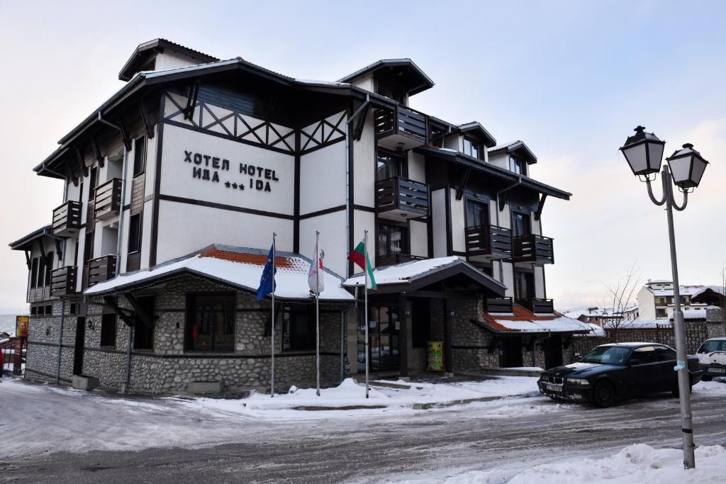 a building with a sign on it in the snow at Hotel Ida in Bansko