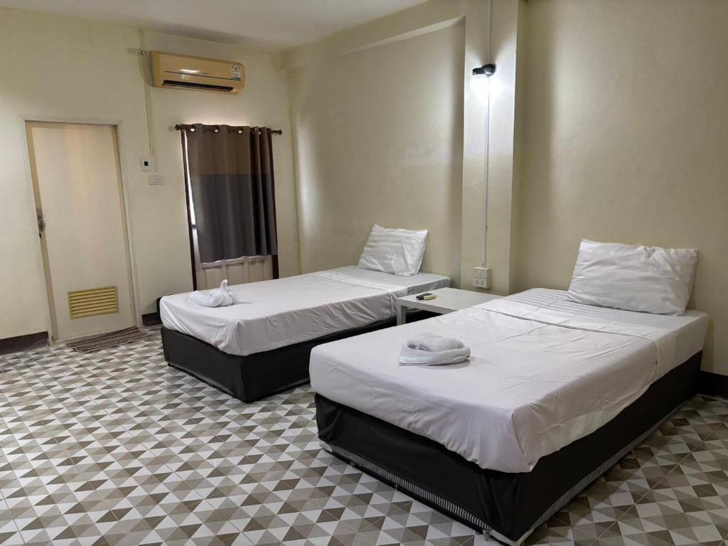 zwei Betten in einem Hotelzimmer mit zwei Bettblenden in der Unterkunft Khamsrithongchai hotel in Mukdahan