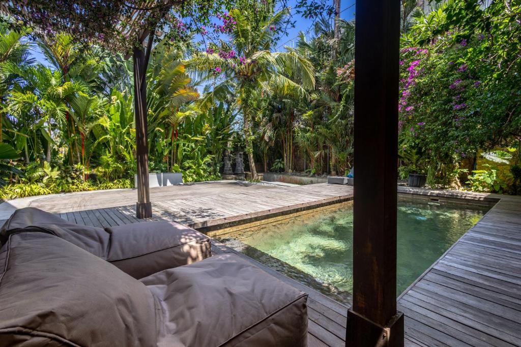 a swimming pool in a resort with a couch next to it at Nami House Balian in Balian