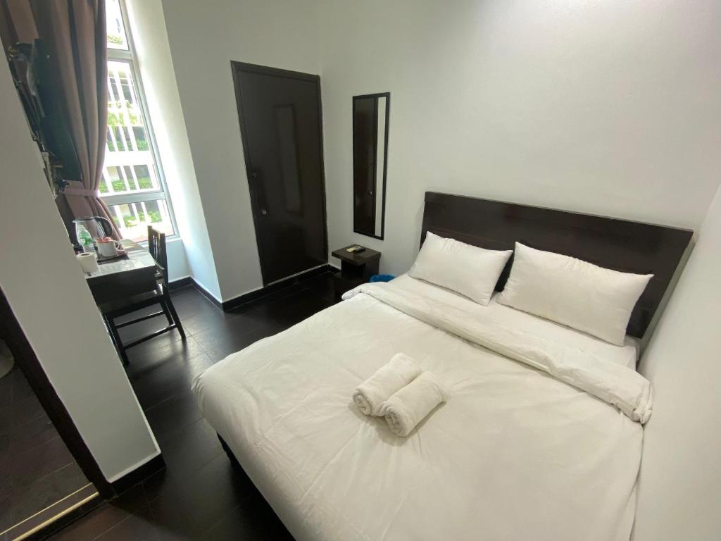 a bedroom with a white bed with two towels on it at Hotel O Friend in Petaling Jaya