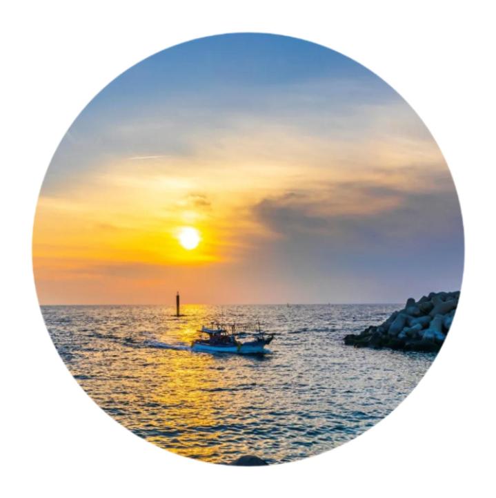 a boat in the ocean with a sunset at The upper room디어퍼룸 in Mahŭl-tong