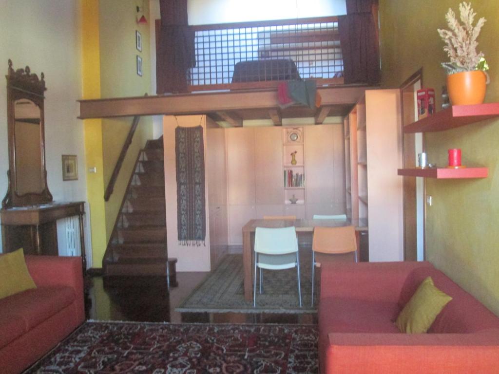 ein Wohnzimmer mit einem roten Sofa und einem Tisch in der Unterkunft La Domus Picta in Verona