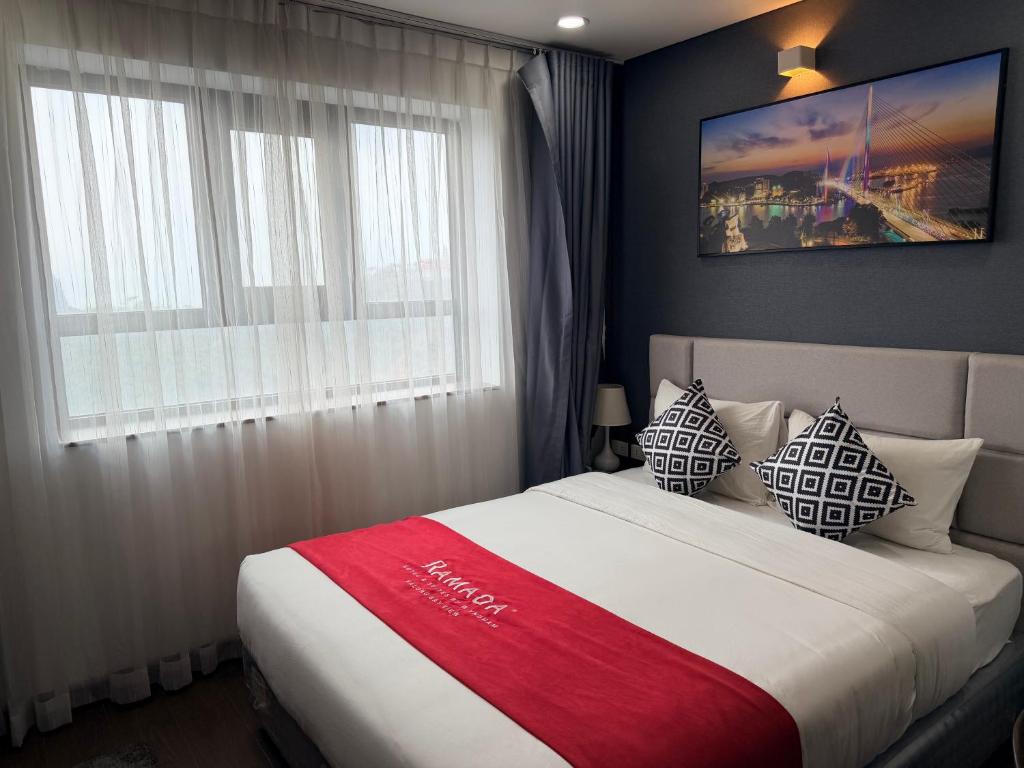 a bedroom with a bed with a red blanket on it at Ha Long 2BR Apartment - Spacious & Modern - Near Center in Ha Long