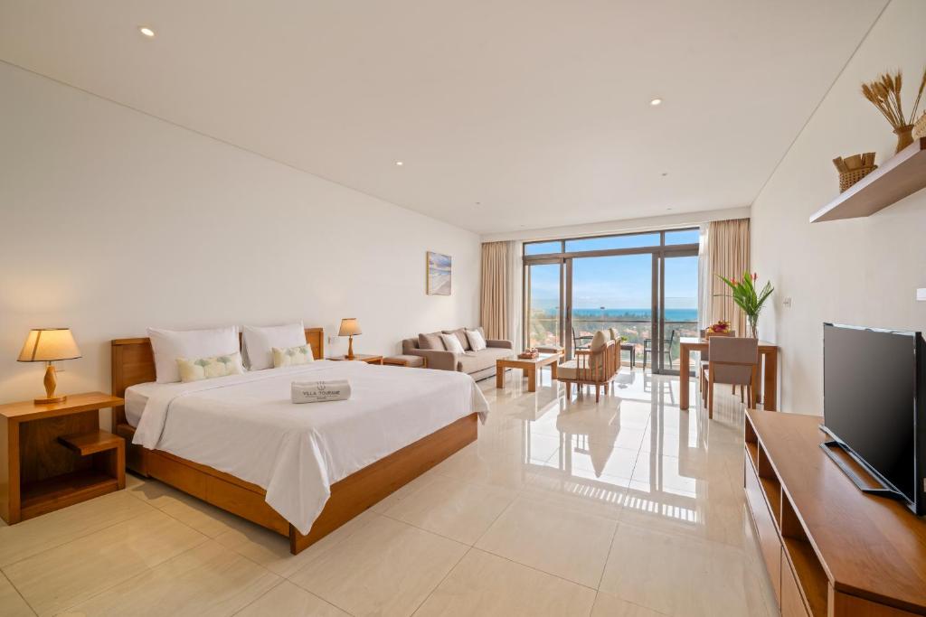 a bedroom with a bed and a living room at The Bada studio apartment - ocean view in Danang