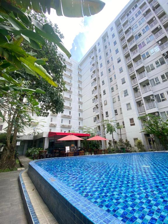 a swimming pool in front of a building at M Apartement in Seturan