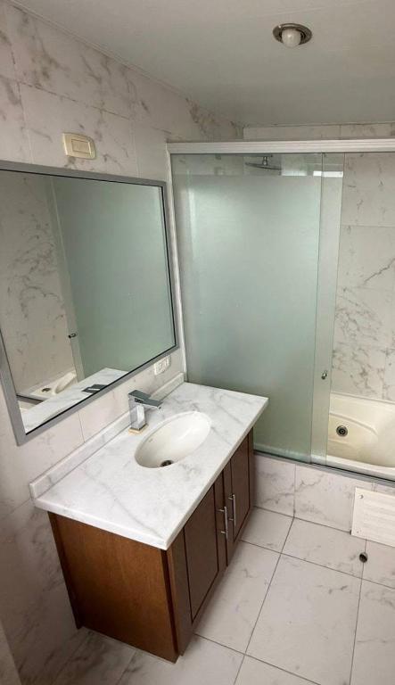 a bathroom with a sink and a mirror and a tub at El departamento de manolo in Cusco