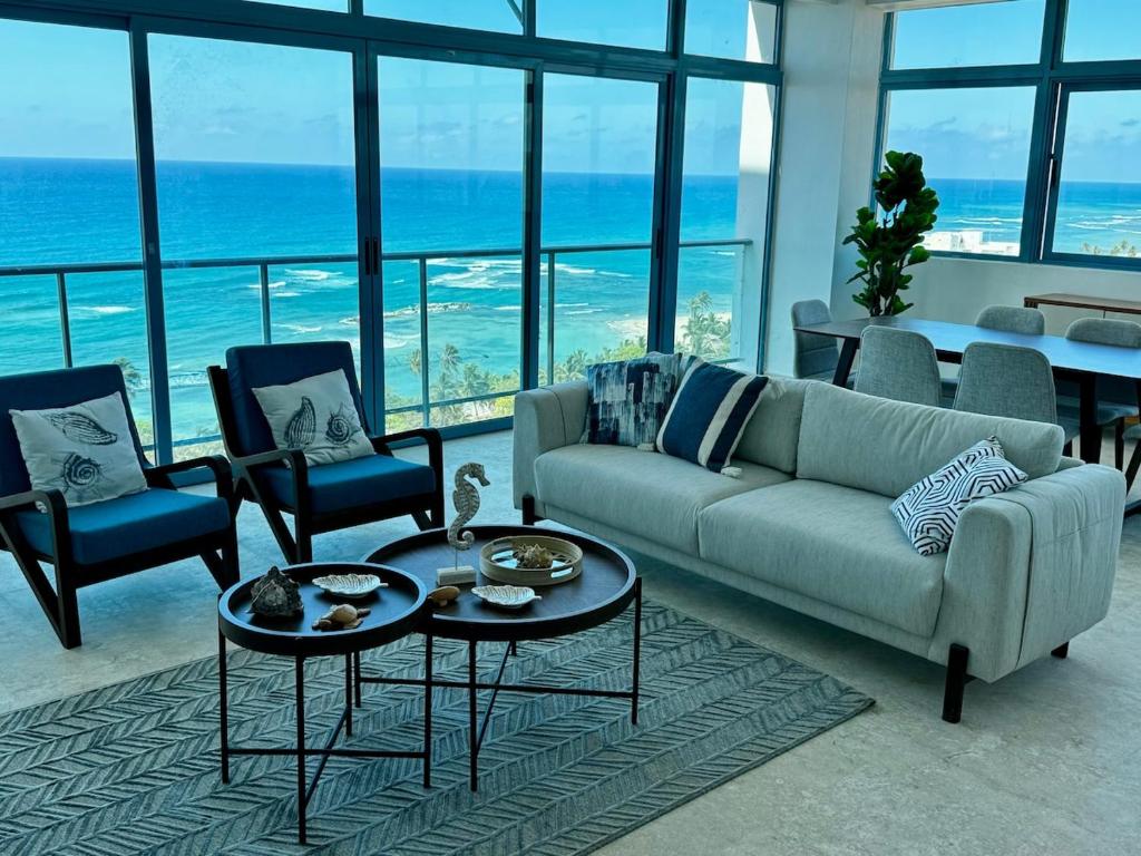 a living room with a couch and chairs and the ocean at JUAN DOLIO 2BR Beach front SALITRE across Club Hemingway in Juan Dolio