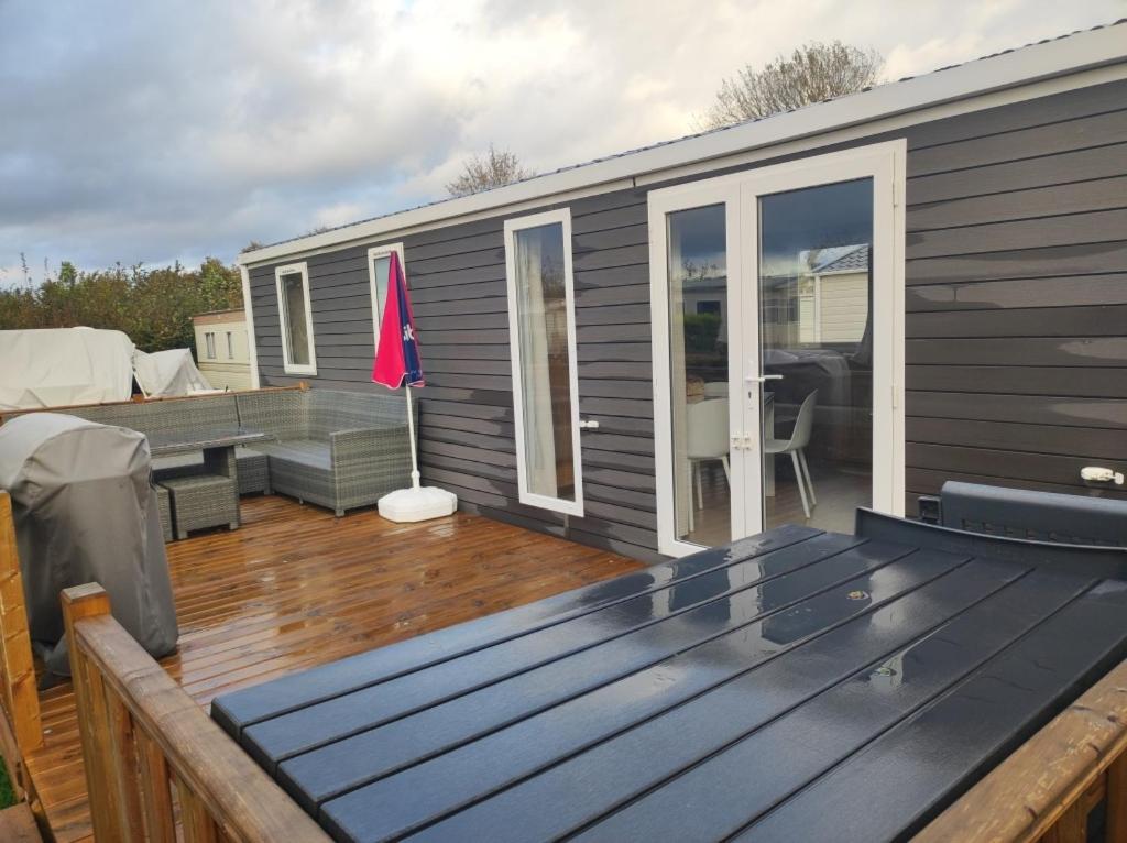 a tiny house with a deck and a patio at Huis-Meerwijck in Kropswolde