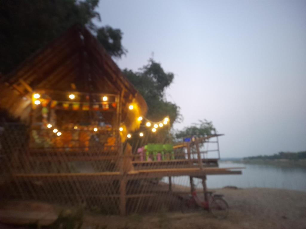 a gazebo on a beach with lights on it at Champasak Backpacker in Ban Mouang
