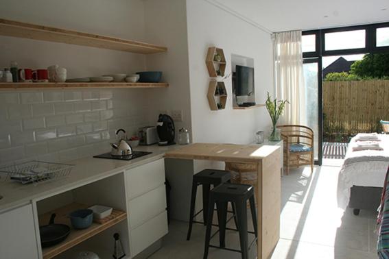 a kitchen with a counter and stools in a room at No. 9 Keurboom in Cape Town