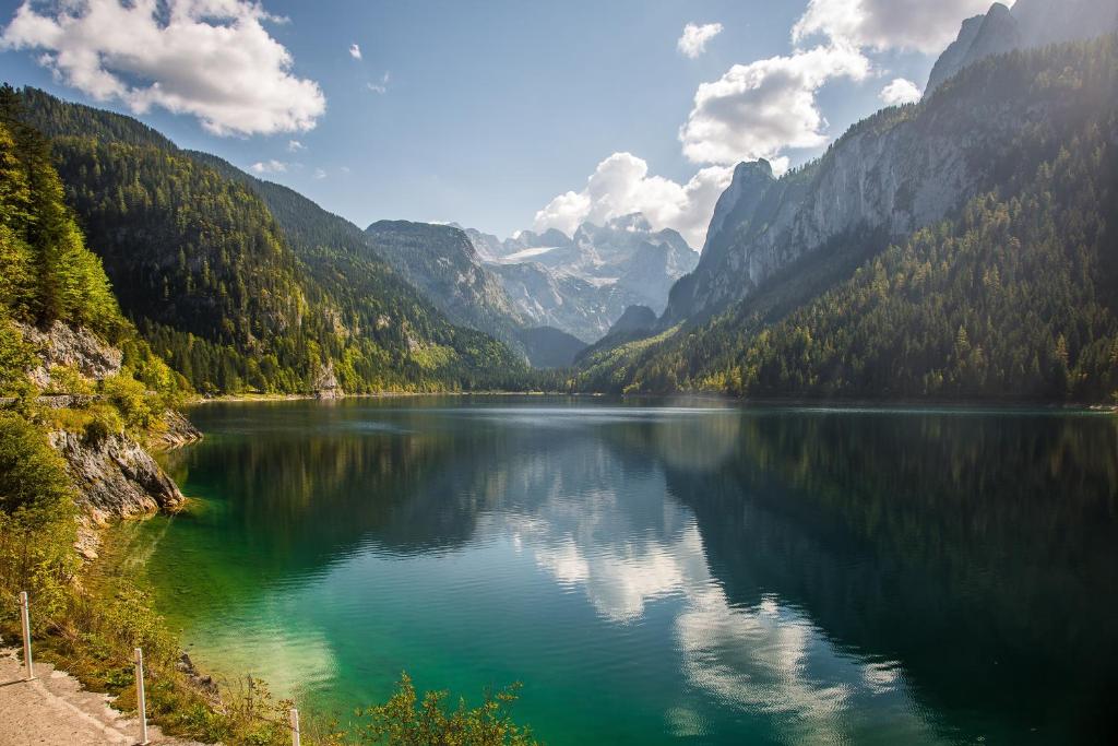 a lake in the middle of a valley with mountains at Stelo Appartments in Gosau