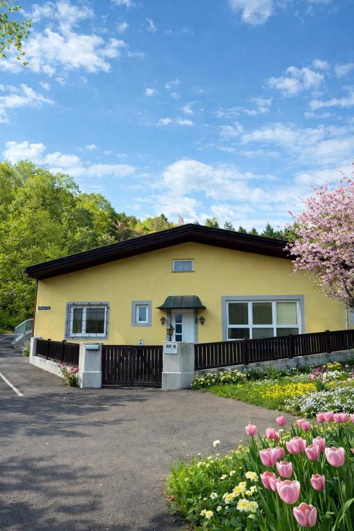 a yellow house with flowers in front of it at Ferienhaus Schneeweiß in Senftenberg