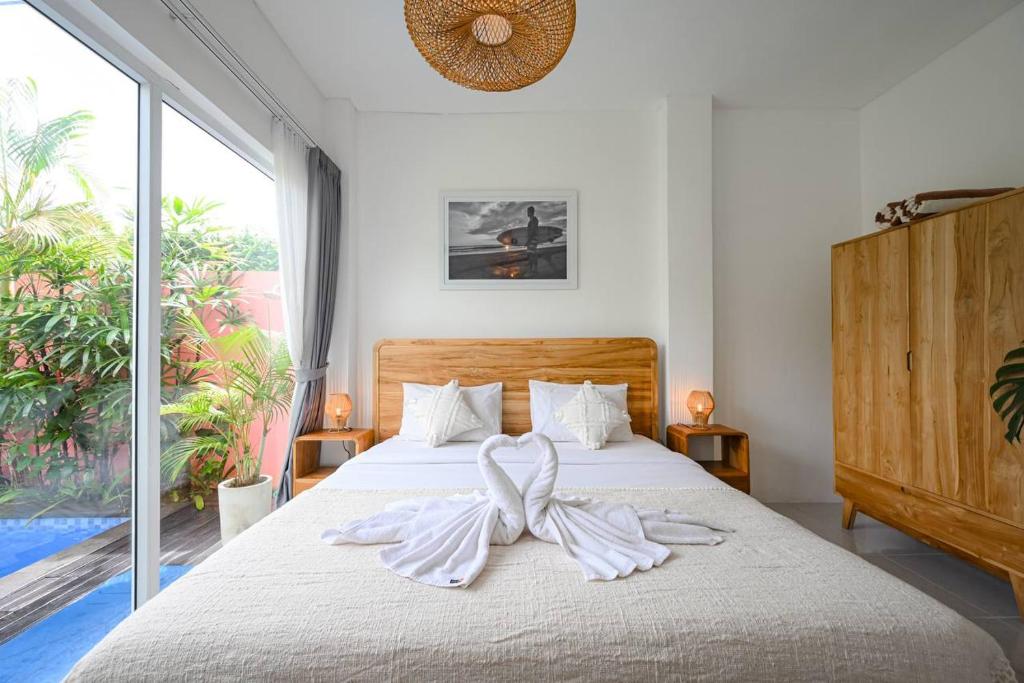 a bedroom with a bed with two white towels on it at Polly Canggu 1BR Private Pool Villa By Bali Bliss Properties in Buduk
