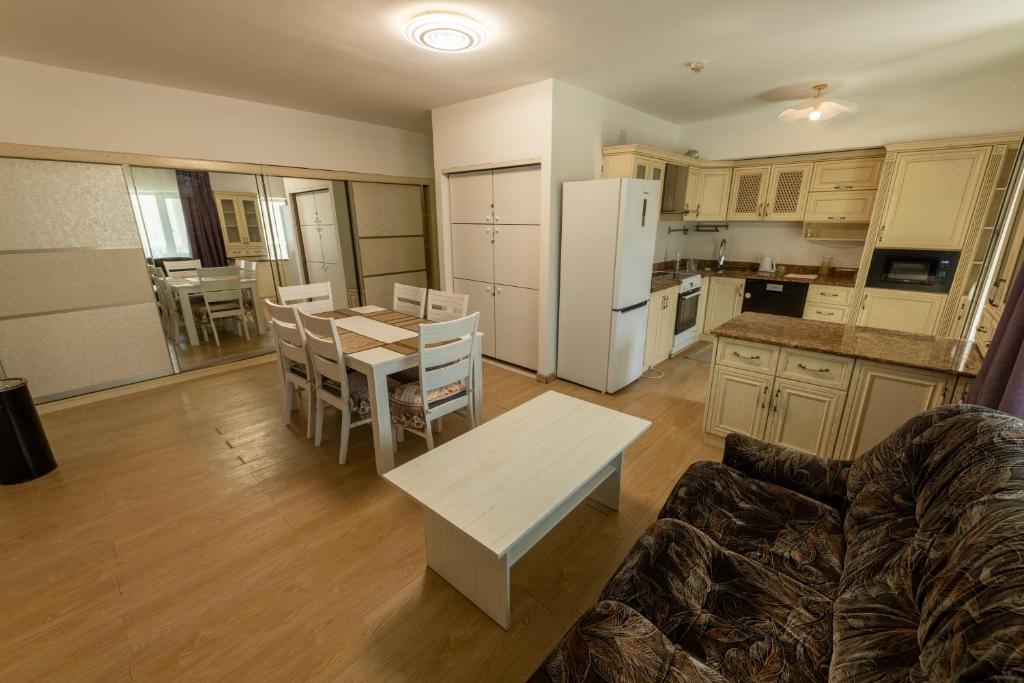a kitchen and living room with a table and a couch at BNM Base Camp - Ulaanbaatar in Ulaanbaatar
