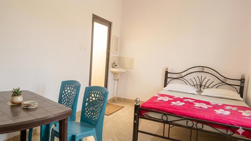 a bedroom with a bed and a table and chairs at Mysore rooms- sgh in Mysore