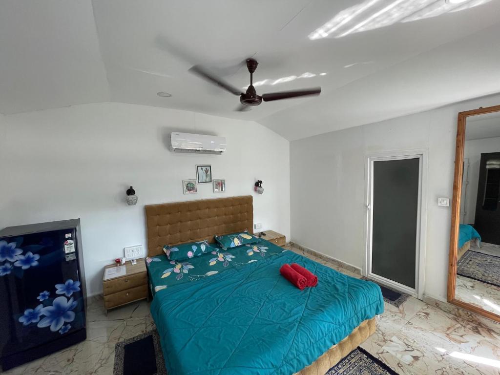 a bedroom with a bed with a blue comforter at Mystic Nest in Canacona