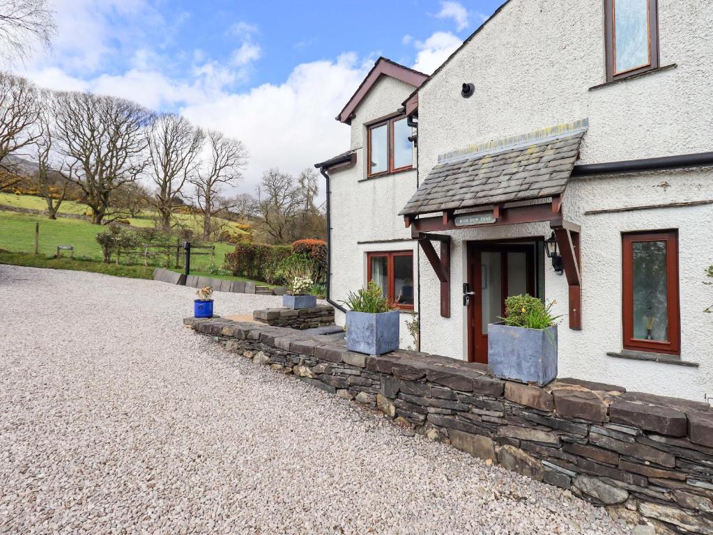 a white house with potted plants in front of it at High Dow Crag in Coniston