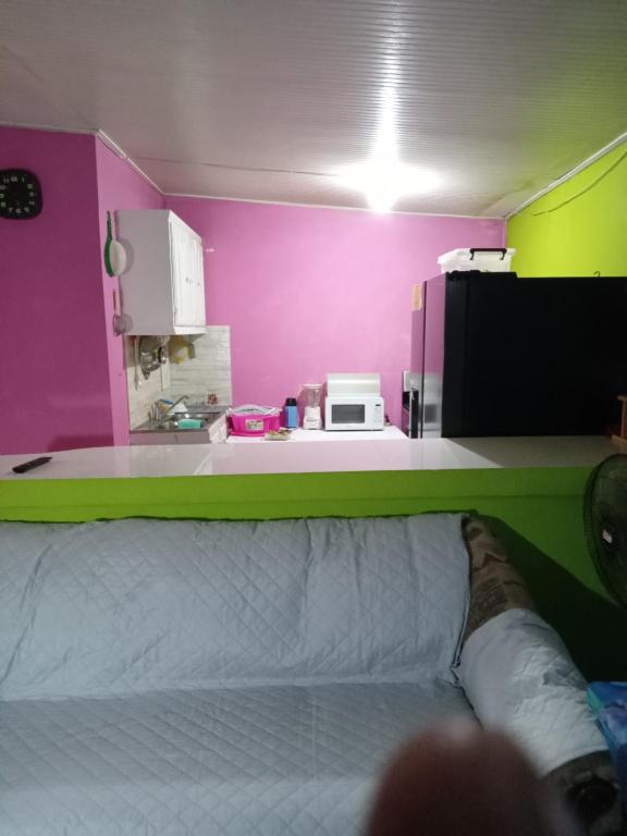ein Zimmer mit einem Bett und einer lila Wand in der Unterkunft Queen room in Bridgetown