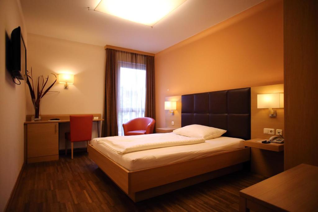 a hotel room with a bed and a desk at Hotel & Restaurant Graf in Sankt Pölten