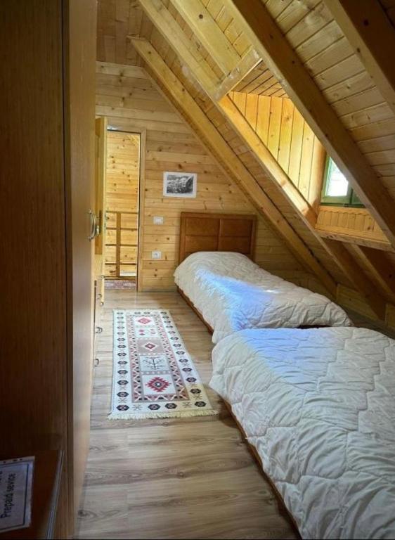 a bedroom with two beds in a log cabin at Eco Camping Valbone in Valbonë