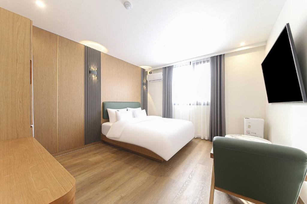 a bedroom with a bed and a flat screen tv at 군산 비욘드 호텔 in Sinp'ung