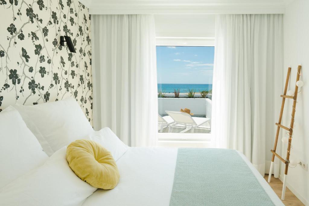 een slaapkamer met een bed en uitzicht op de oceaan bij La Concha Boutique Apartments - Adults Only in Arrecife