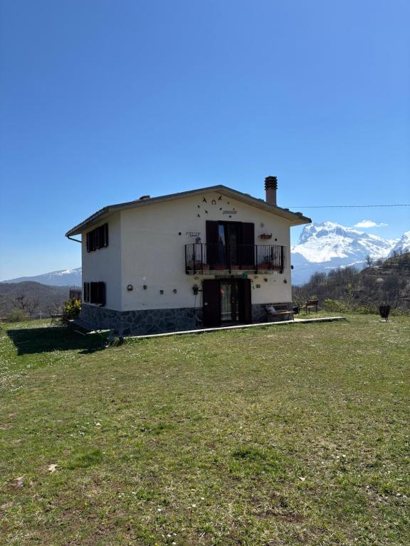a house in a field with mountains in the background at Casa PerlAmbra Abruzzo in Casagreca