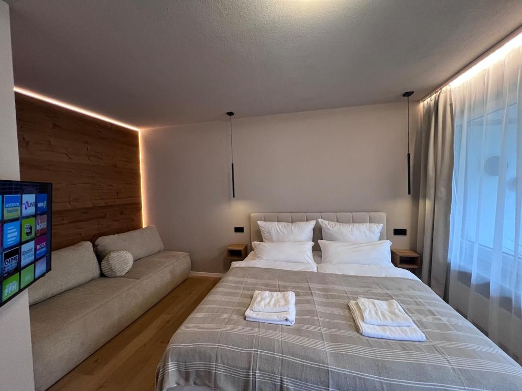 a bedroom with a large bed and a couch at MOREHOME Zentral Parkplatz Balkon nähe Therme in Bad Wörishofen