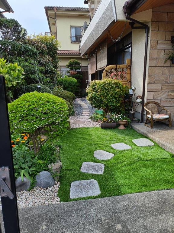 a garden with grass and rocks in a yard at 菊の宿 民泊 in Iidamachi