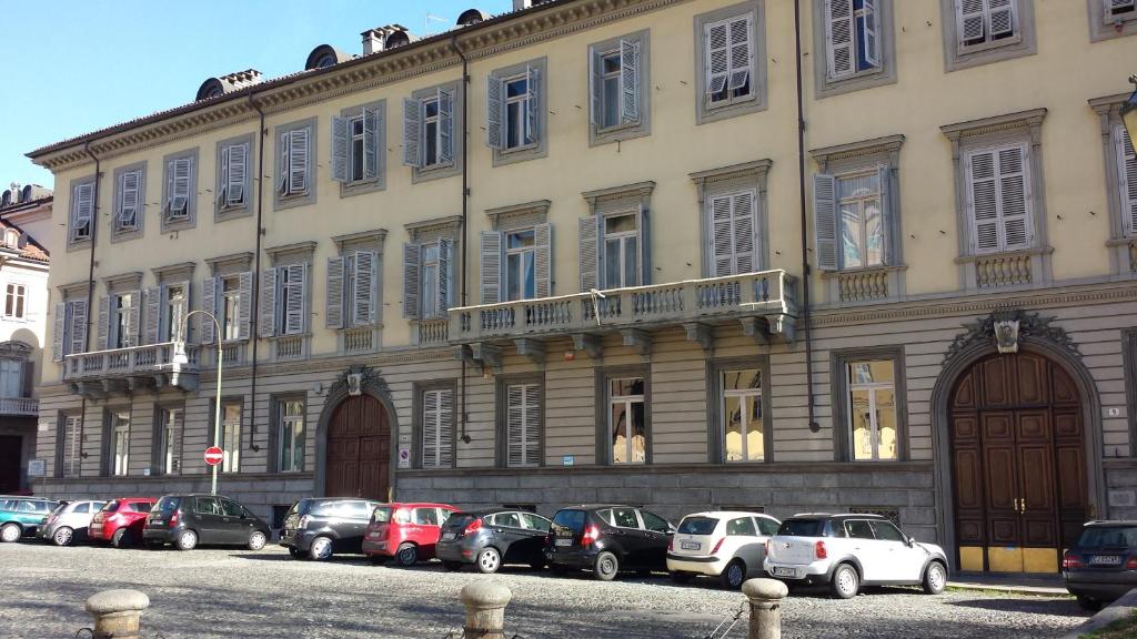 un grand bâtiment avec des voitures garées devant lui dans l'établissement Cit Ma Bon, à Turin