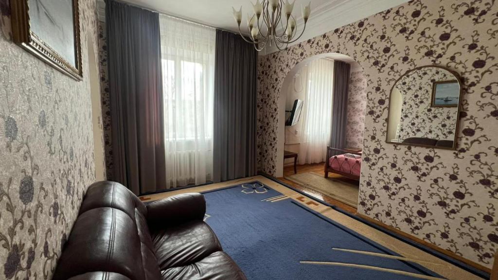 a living room with a leather couch and a mirror at Гостиница Орал in Zhezdi