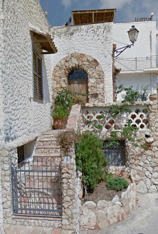 a stone building with stairs and plants on it at Rustic-style apartment in LMP