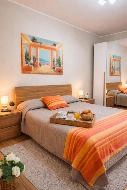 a bedroom with a bed with a tray of food on it at Casa Flora in Biella