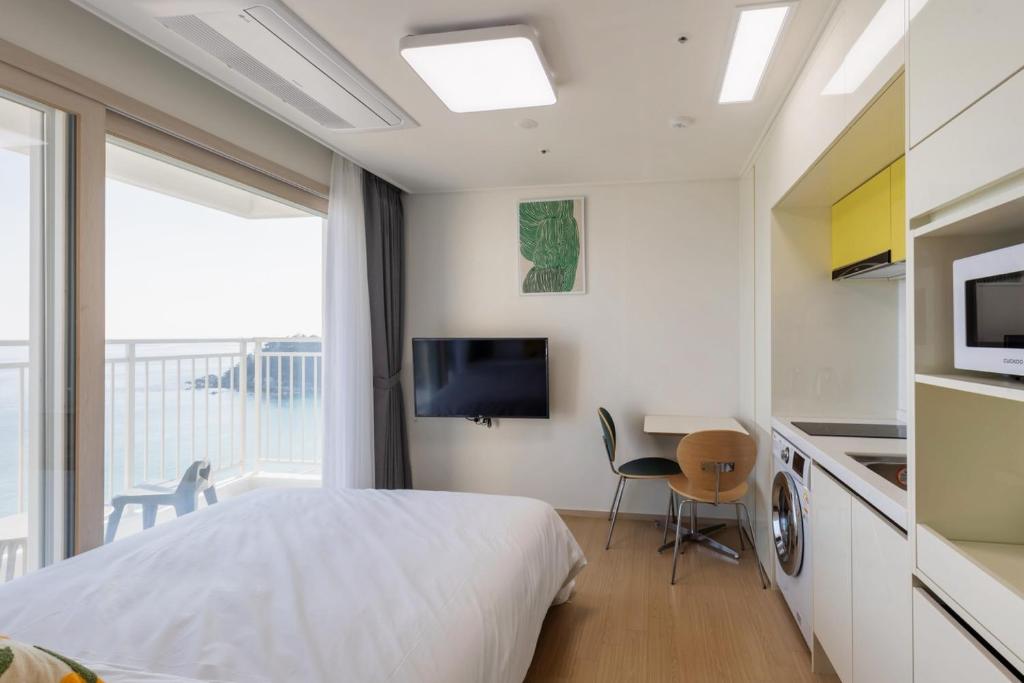 a bedroom with a bed and a desk and a tv at 양양 죽도해변호텔 오션뷰스테이 일출뷰 바다뷰 힐링뷰 낭만뷰 넷플릭스완 in Saetchak