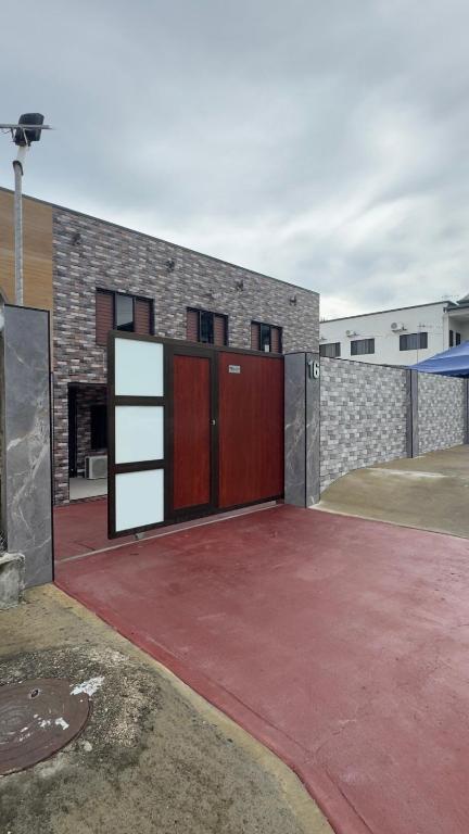 a garage with two red doors and a brick building at Raza villa in Lautoka