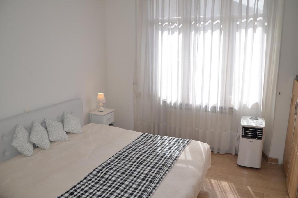 een slaapkamer met een bed met witte gordijnen en een raam bij Spacieux & Lumineux appartement - Centre de Cannes in Cannes