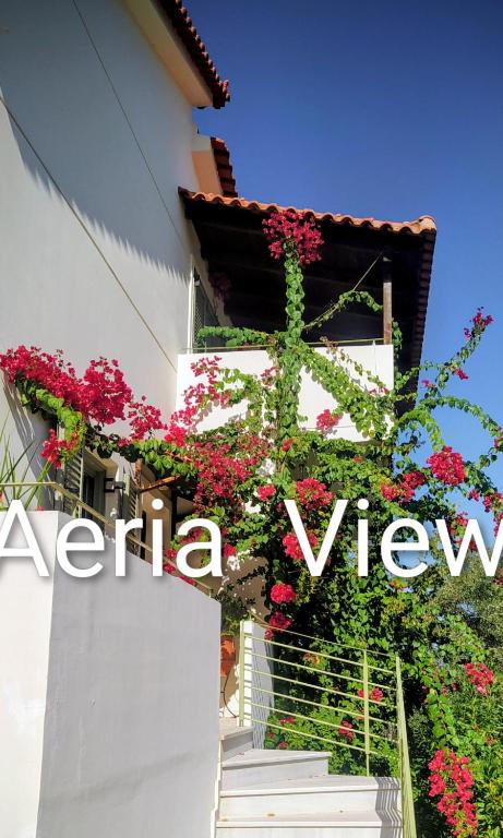 ein weißes Gebäude mit Blumen an der Seite in der Unterkunft Aeria View in Éva