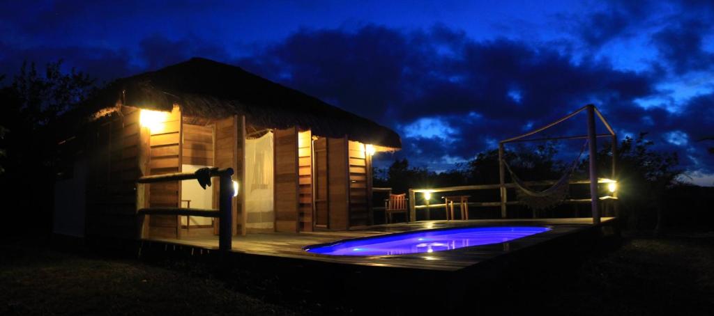 a small building with a swimming pool at night at Pura Vida Bahia in Abadia