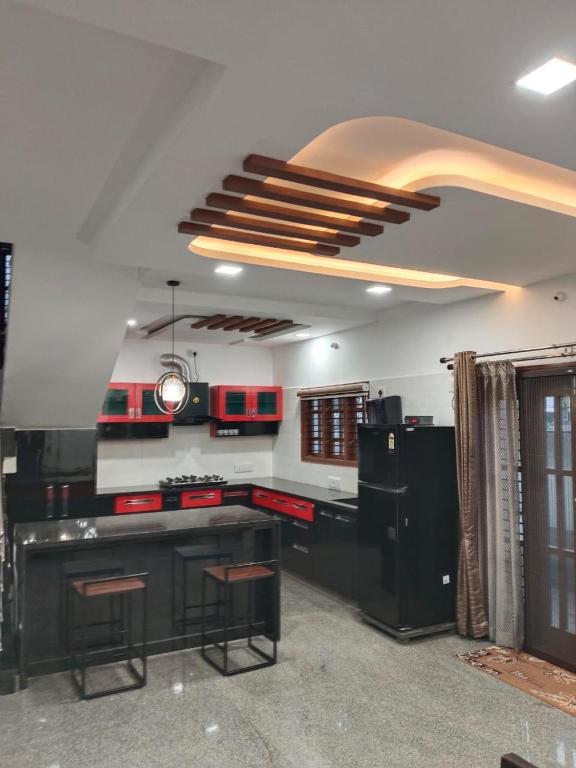 a kitchen with black cabinets and a ceiling at Relaxing Villa in Mysuru! in Mysore