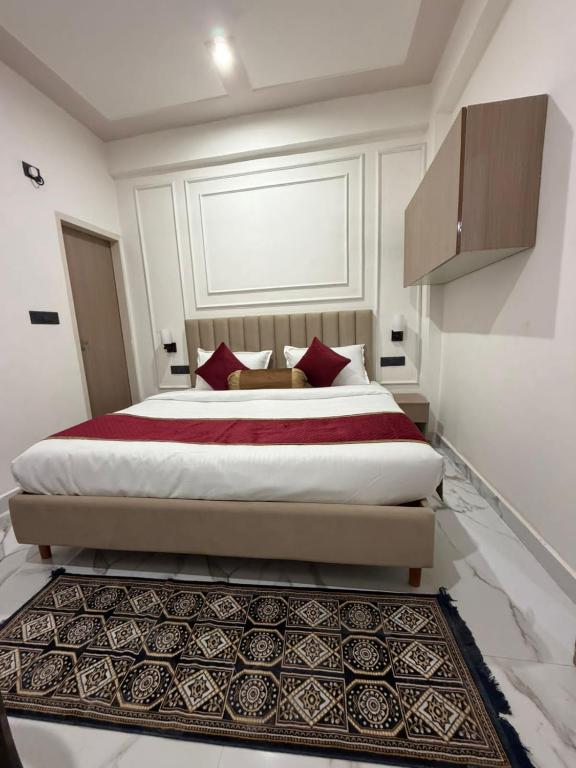 a bedroom with a large bed with red pillows at A One Residency in Bahora