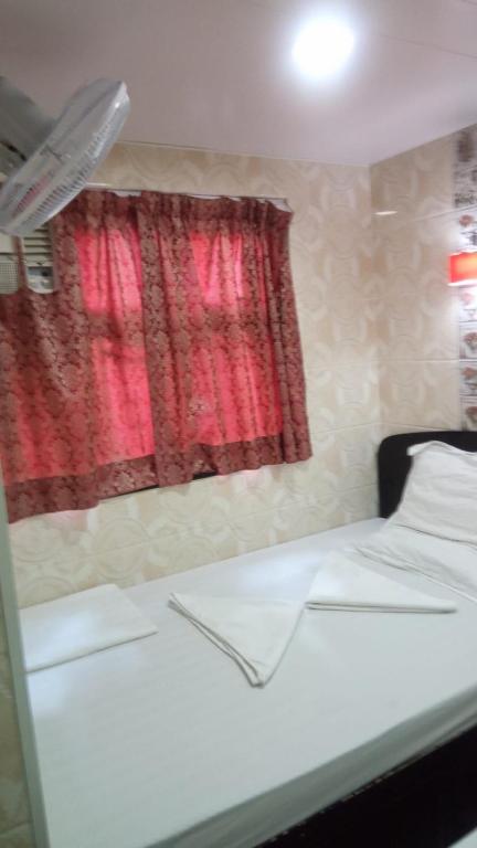 a bedroom with a white bed and a red window at Mabuhay INN in Hong Kong