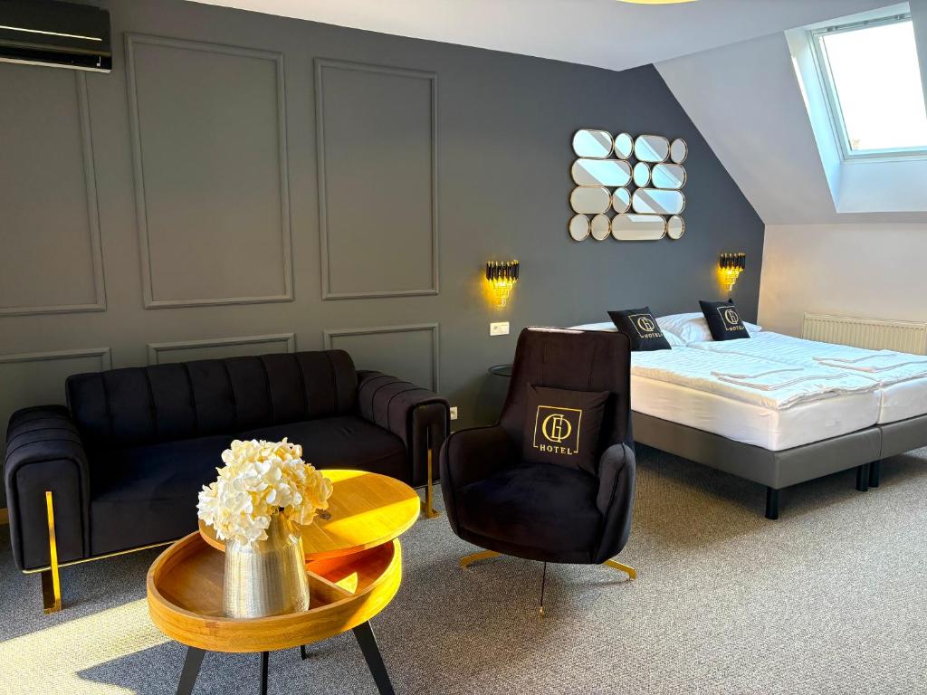 a bedroom with a bed and a couch and a table at Grand Danube Hotel in Komárno