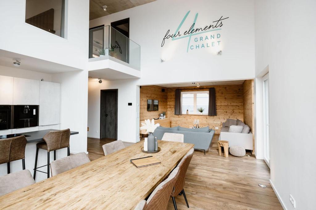 a kitchen and dining room with a wooden table at FourElements Grand Chalet in Blankenburg