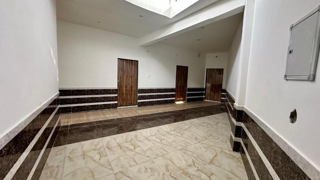 an empty room with three doors and a hallway at Anmol Hotel And Restaurant in Chandausi