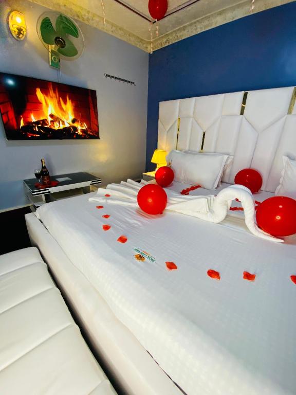 a bedroom with a white bed with red decorations on it at Royal Lake View Gardens in Kampala