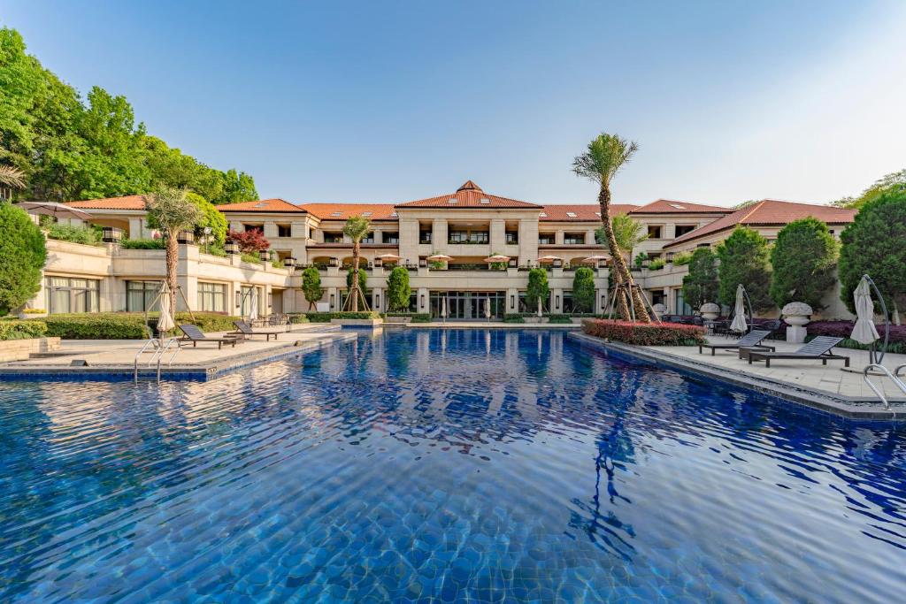 a large swimming pool in front of a building at Hangzhou Rose Garden Resort & Spa in Hangzhou